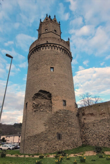 Ein runder Turm lehnt an einer Stadtmauer