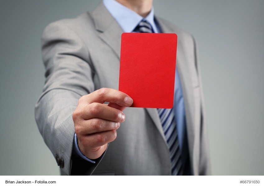 Ein Mann im Business Dress zeigt die Rote Karte